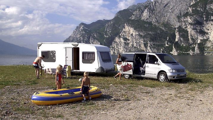 Eine Familie campiert mit ihrem Wohnwagen an einem idyllisch gelegen See. Aufnahme vom 11.5.2000. Ein Urlaub mit dem Wohnwagen oder Caravan hat viele Vorteile: Mit dem Wohnwagen hat man sein Bett immer dabei und muss nicht im Hotel übernachten. Und außerdem kann man fast überall, wo es gefällt und zugelassen ist, seinen Wohnwagen parken und einfach Urlaub machen fernab vom Trubel und Pauschaltourismus.