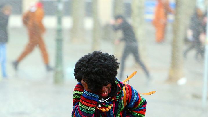 ARCHIV - 08.02.2016, Nordrhein-Westfalen, Düsseldorf: Narren flüchten am Rosenmontag in Düsseldorf vor Regen und Sturm. 2016 hat Düsseldorf wegen eines heftiger werdenden Sturms kurzfristig den Rosenmontagzug abgesagt. In diesem Jahr könnte Tief «Bennet» den Karnevalisten den Rosenmontag verhageln. (zu dpa/lnw «Sturm an Rosenmontag - Müssen große Umzüge abgesagt werden?» ) Foto: David Young/dpa +++ dpa-Bildfunk +++