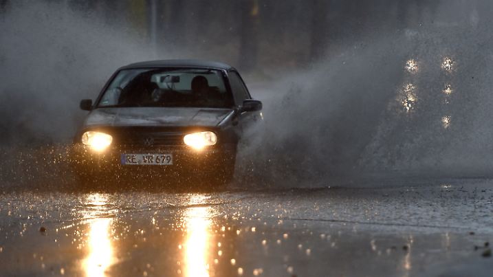 09.03.2019, Nordrhein-Westfalen, Gelsenkirchen: Ein Auto fährt langsam durch eine tiefe Pfütze die sich durch Starkregen auf einer Straße gebildet hat. Mit Sturmböen und Gewitter hat Sturmtief Dragi am Samstagnachmittag in Nordrhein-Westfalen für Probleme im Bahnverkehr und auf den Straßen gesorgt. (zu dpa «Sturm sorgt für Zugausfälle im Ruhrgebiet - Autobahn 40 überflutet») Foto: Caroline Seidel/dpa +++ dpa-Bildfunk +++