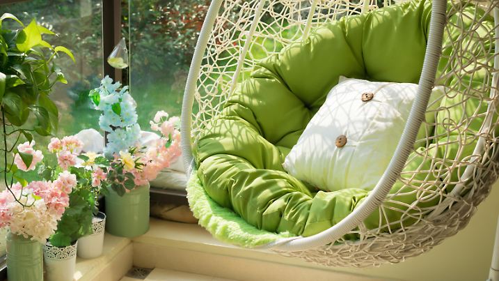 garden swing with mattress and cushion in a balcony in the morning