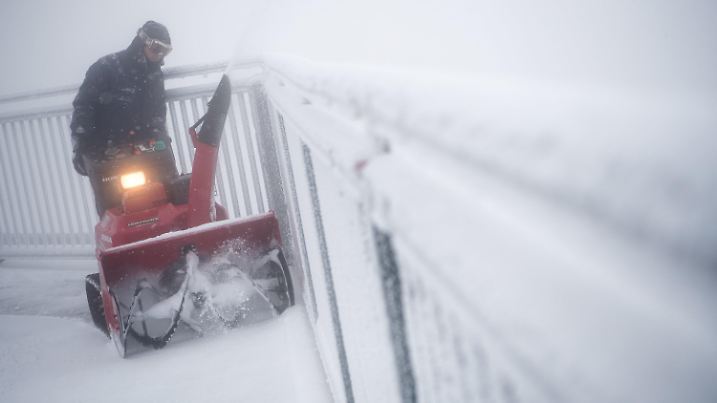 ARCHIV - 26.08.2018, Bayern, Grainau: Ein Mann fährt mit einem Schneepflug auf dem Gipfel der Zugspitze über die Aussichtsplattform. Foto: Sven Hoppe/dpa +++ dpa-Bildfunk +++
