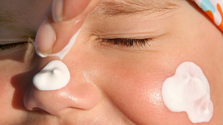 Ein Kind bekommt am Freitag (29.04.2011) in Berlin das Gesicht mit Sonnencreme eingecremt. Foto: Stephanie Pilick dpa/lbn