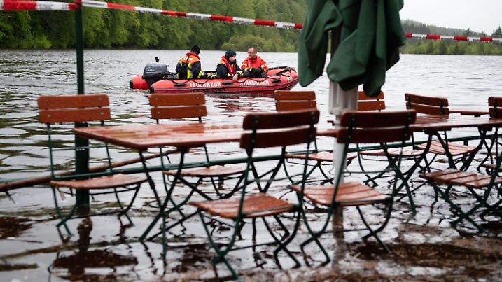 ARCHIV - 21.05.2019, Bayern, Straßlach: Feuerwehrmänner fahren mit einem Boot über den Deininger Weiher, der durch den starken Regen einen hohen Wasserstand hat und bereits einen Biergarten überflutet hat. (zu dpa «Studie: Klimawandel verschärft Hochwasserereignisse in Deutschland ») Foto: Sven Hoppe/dpa +++ dpa-Bildfunk +++