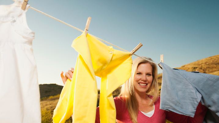 Woman hanging laundry on clothesline Keine Weitergabe an Drittverwerter.